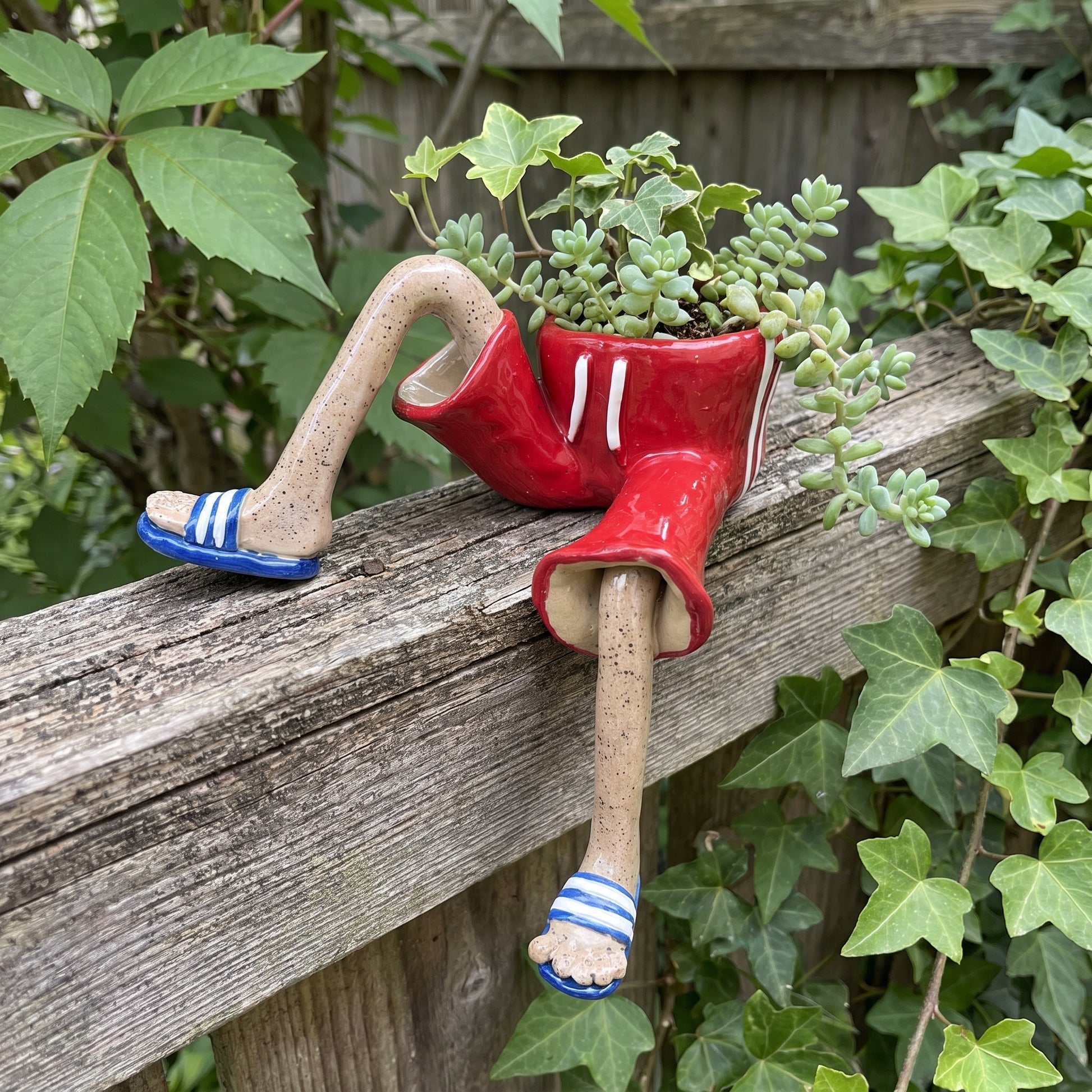 Red welly boot dangling-legs plant pot