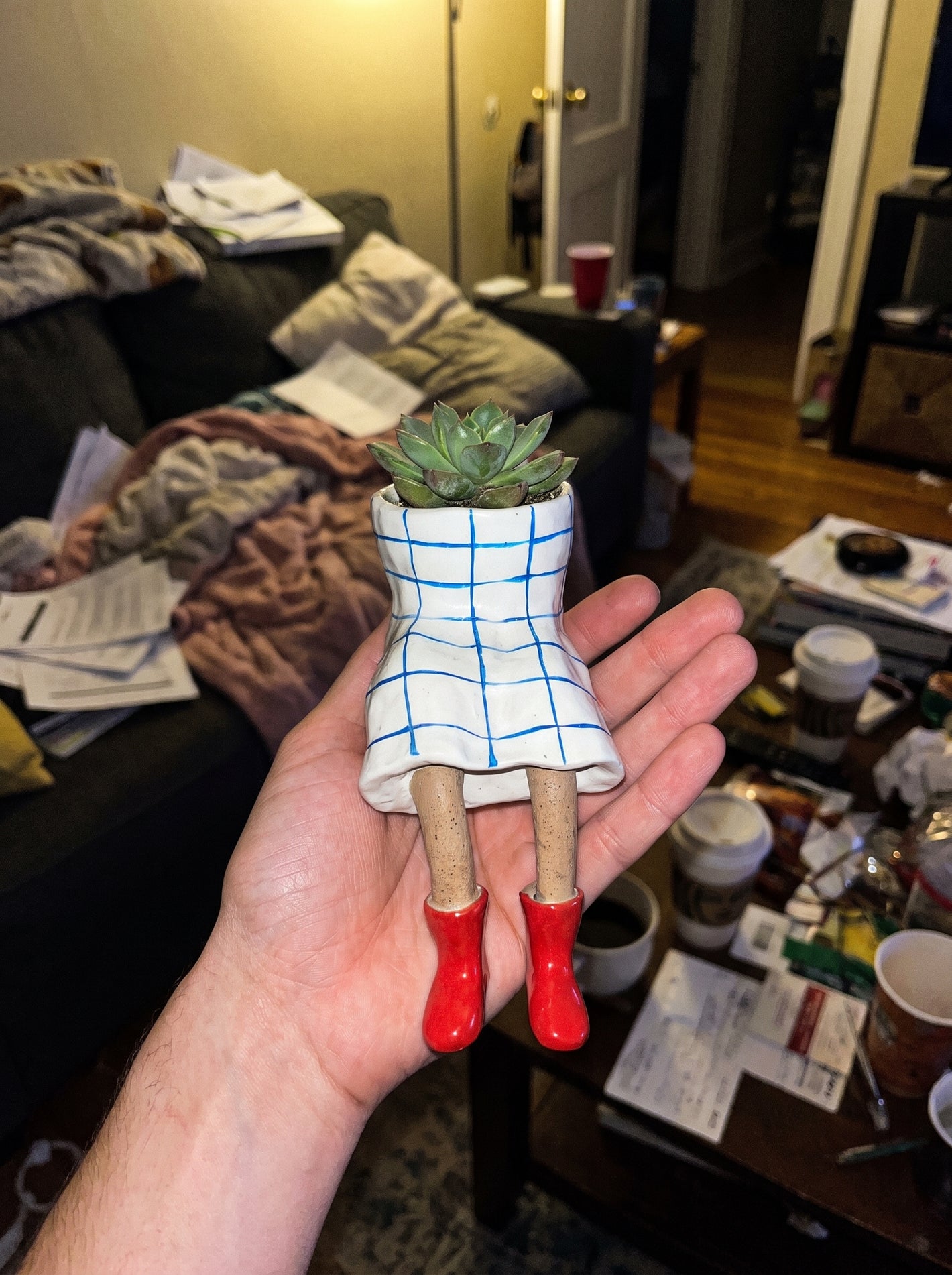 Customer holding a dangling-legs plant pot in hand