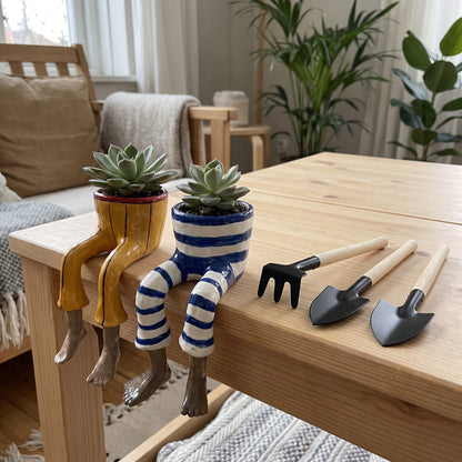 Mini garden tools shown next to dangling-legs plant pots for scale