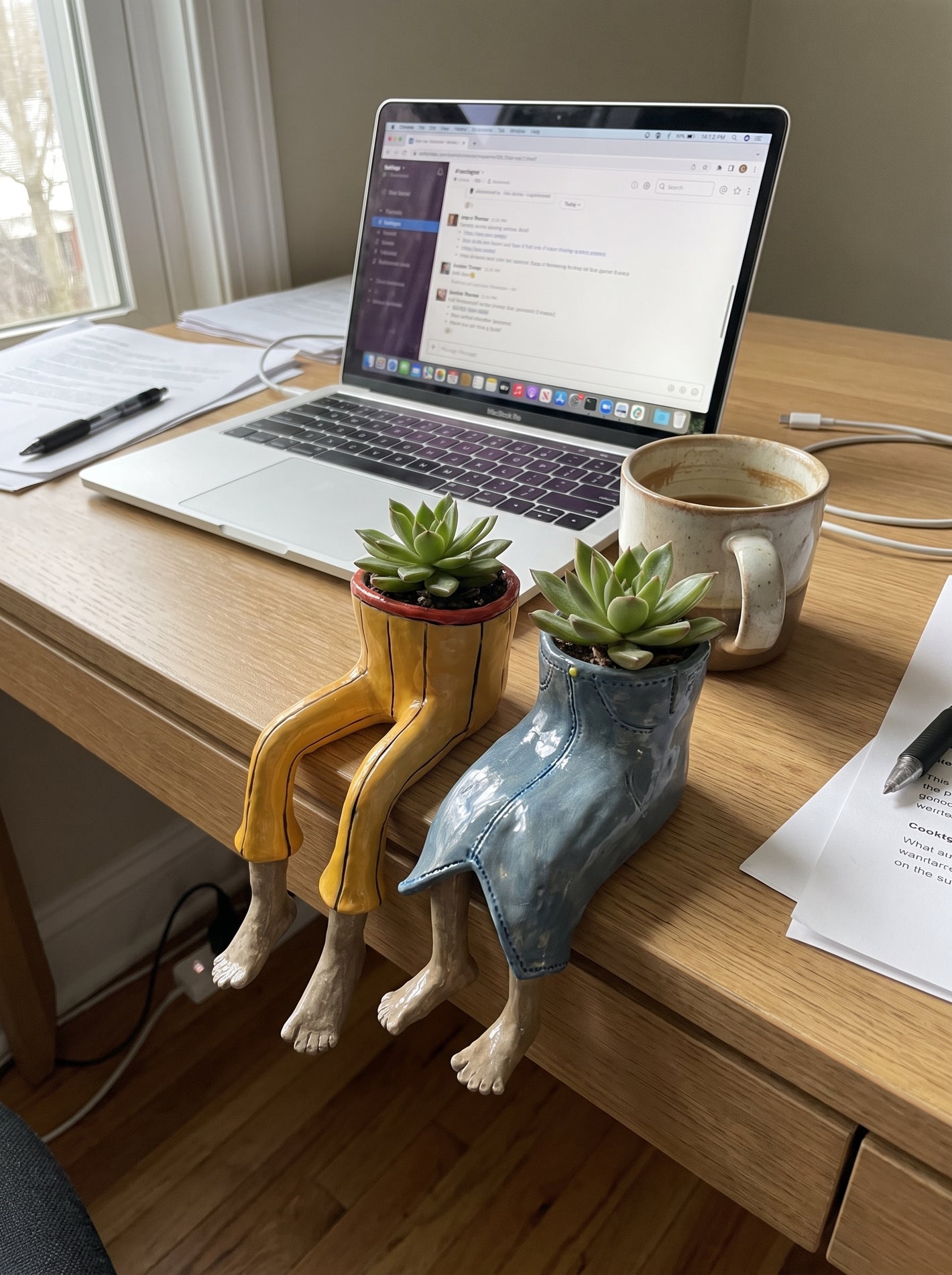 Two dangling-legs plant pots on a work desk