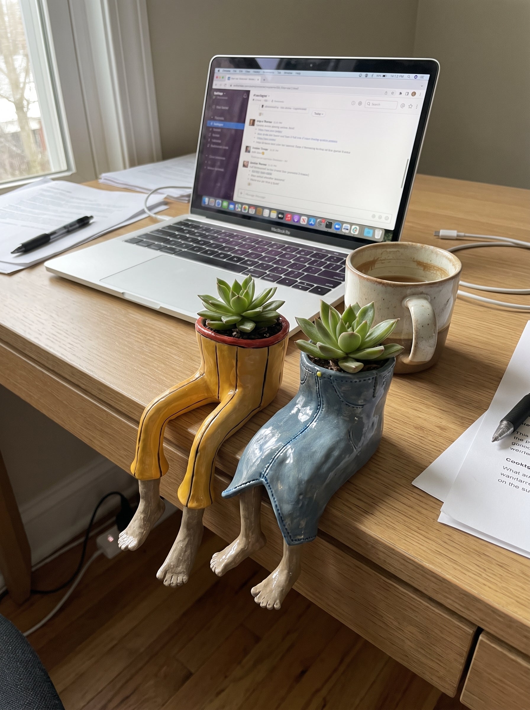 Two dangling-legs plant pots on a work desk