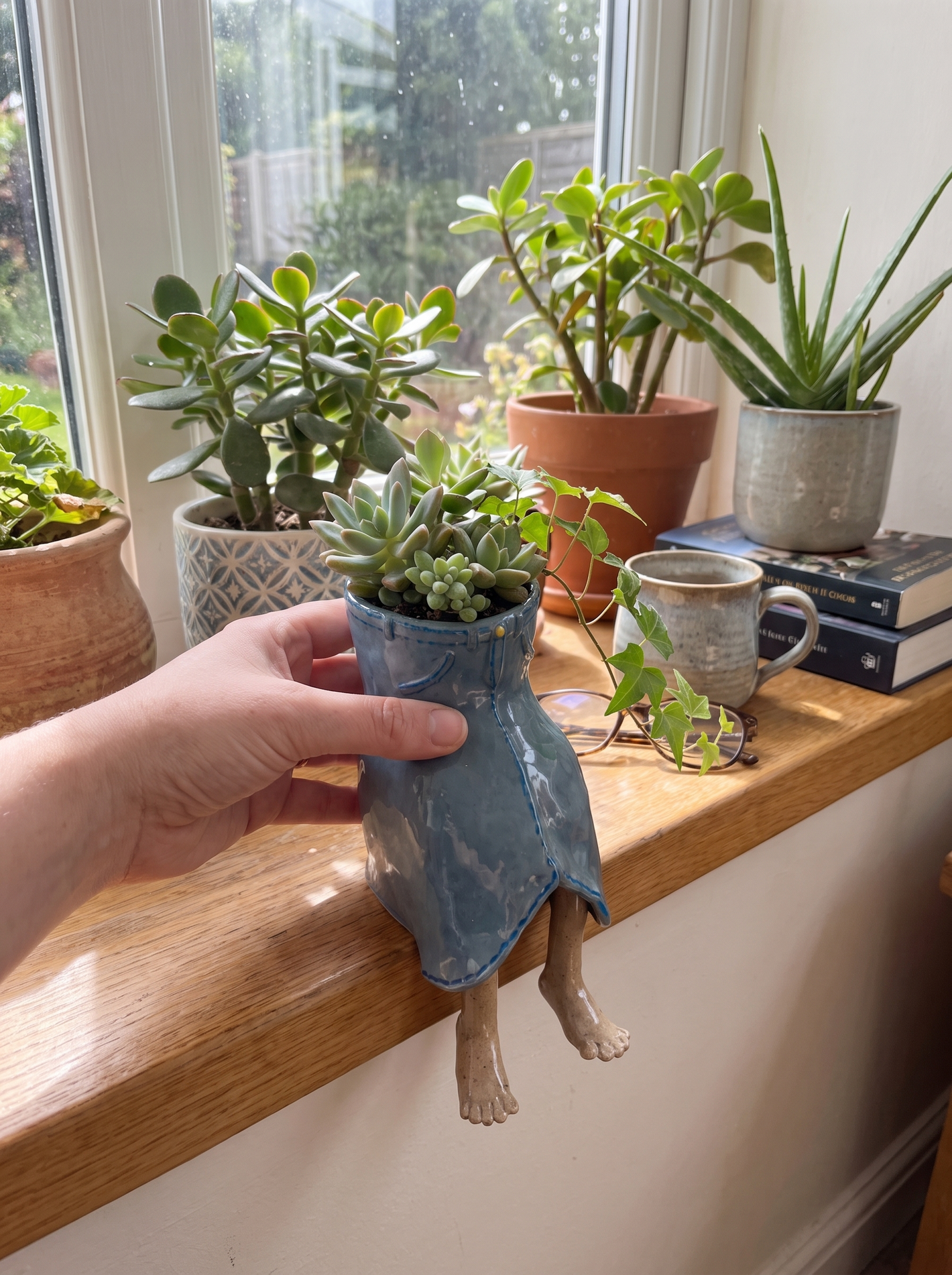 Denim dangling-legs plant pot on a sunny windowsill